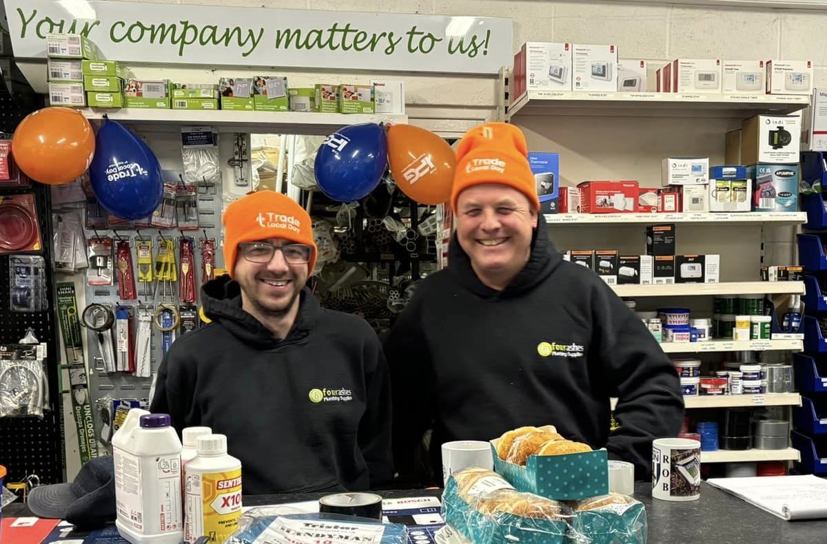 An IPG member staff in store showing off their trade local day garments and cakes to give away